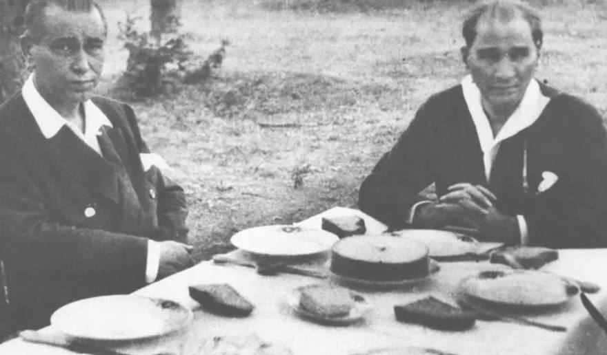 A small table at the water's edge; a few people seated around it.